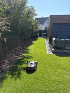 Jardin engazonné avec robot de tonte et coin salon