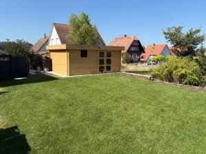 Pelouse engazonnée et abri de jardin en bois