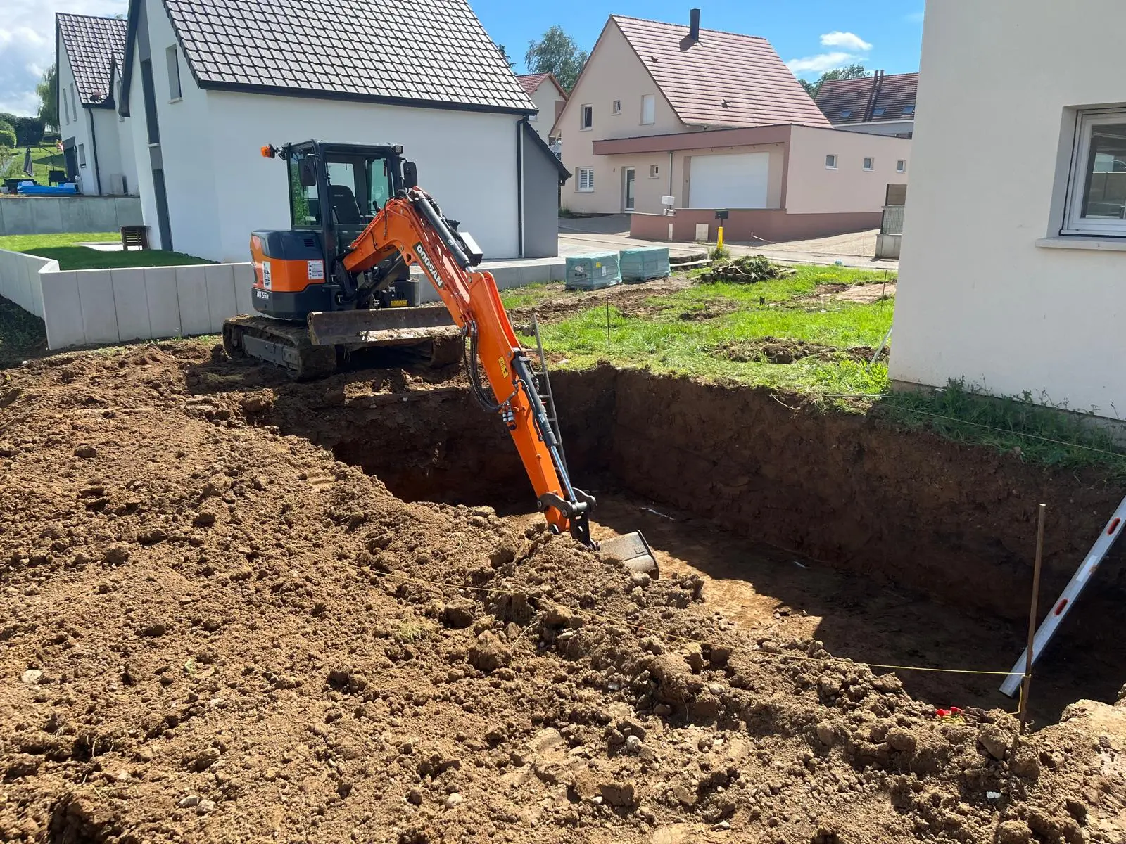 Mini-pelle en cours de terrassement dans un jardin