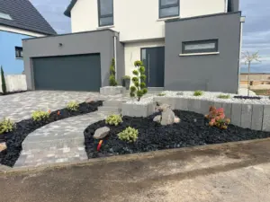 Chemin pavé et massifs plantés sur paillage d’ardoise devant une maison