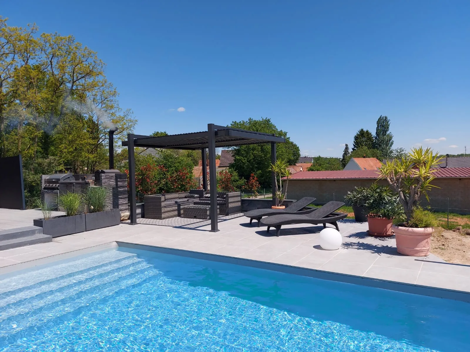 Piscine sur mesure avec terrasse et pergola, réalisée par Green & Blue
